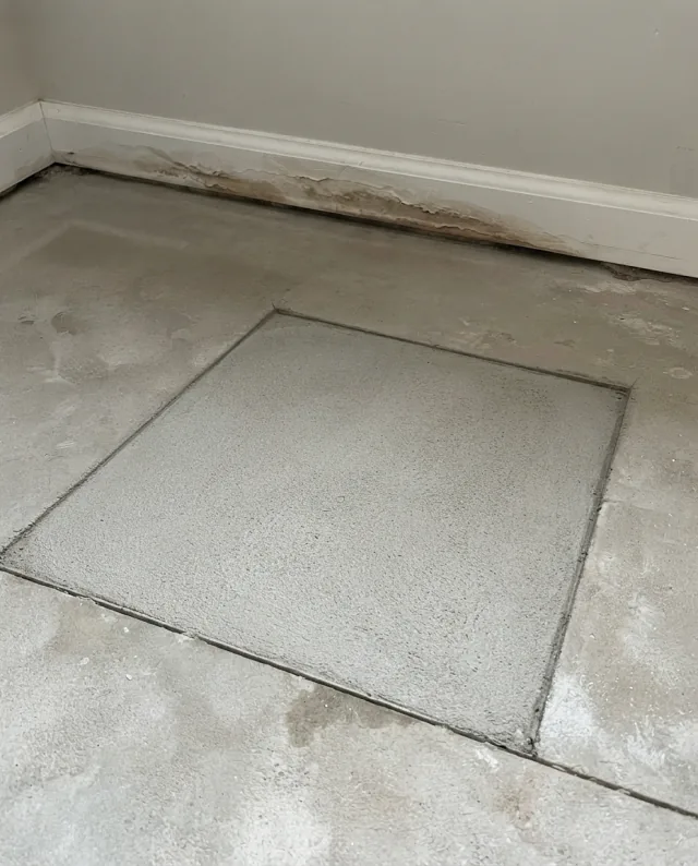 Dry concrete floor with a clean flush patch — after slab leak repair